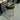 A chrome bar stool with a black and yellow padded seat featuring the MINN KOTA logo, set inside a workshop.